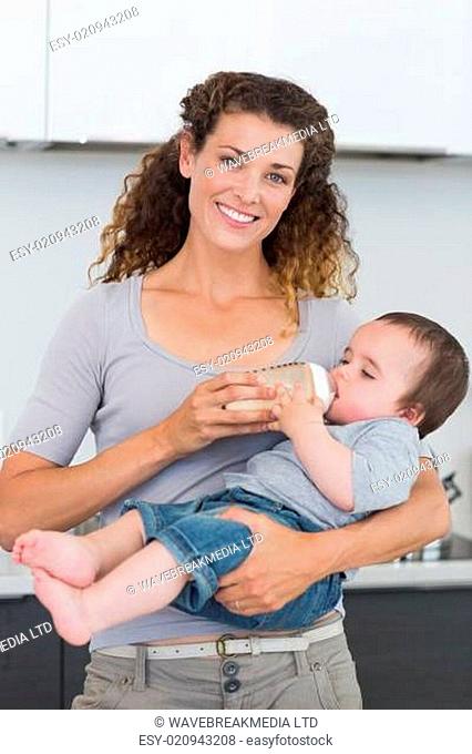 Happy mother feeding milk to baby
