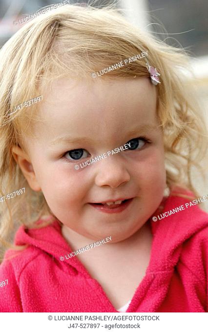 Headshot , 3 year old girl playing at nursery, smiling into camera