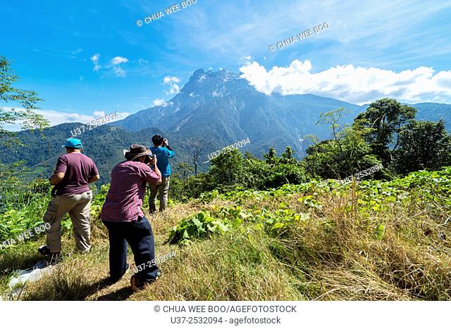 Three photographers taking photo of Mount Kota Kinabalu, Sabah, Malaysia