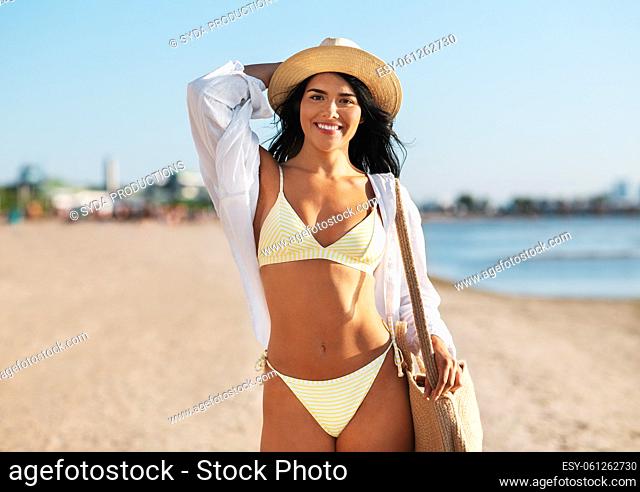 happy woman in bikini and shirt walking on beach