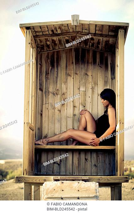 Caucasian woman sitting in cabana on beach