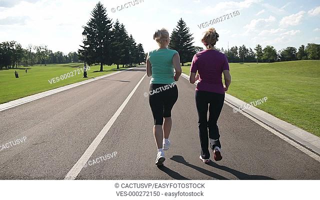 Back view of running women jogging in the park