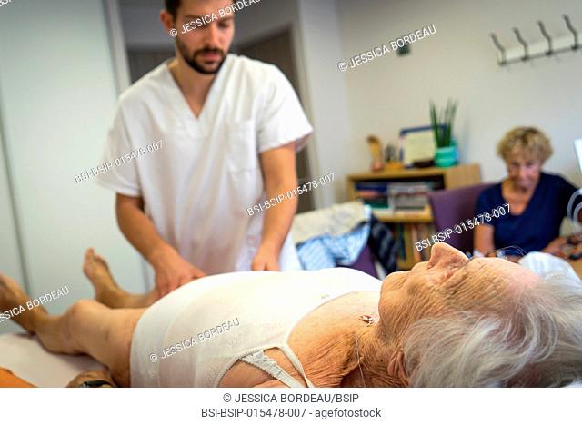 Reportage in an osteopathy practice in Héyrieux, France. Osteopathy session for a 98-year old woman suffering from back and arthritis pain