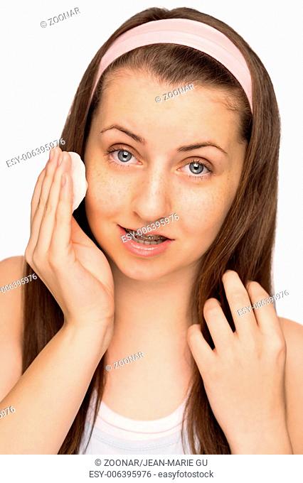 Girl cleaning face with cotton pad isolated