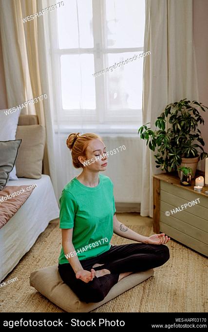 Woman with eyes closed meditating at home