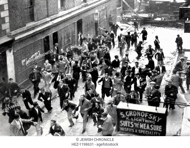 'Battle of Cable Street', Aldgate, London, 5th October 1936. An anti-Fascist crowd, some of them carrying missiles, run from a barricade they have erected near...
