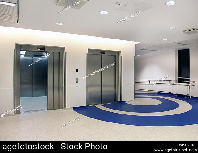 Elevators in the atrium of a new modern hospital, blue patterns on the floor