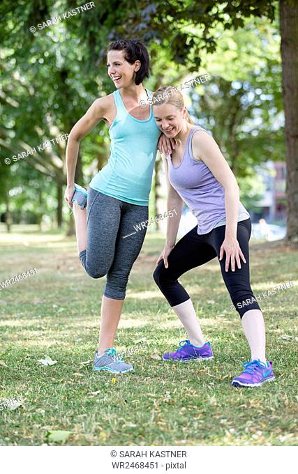 Two women stretch, warm up