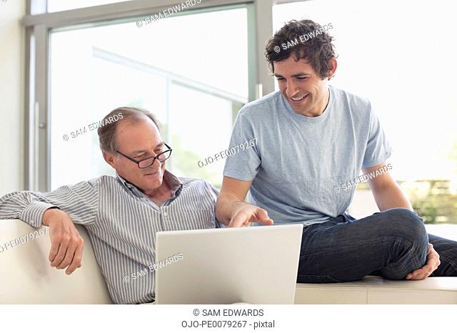 Men using laptop together