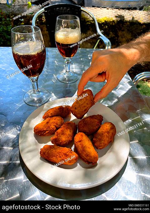 Croquettes serving with two glasses of beer in a terrace. Spain