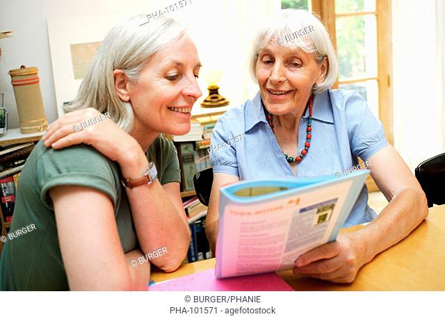 Elderly woman reading a brochure on service or facility dedicated to elderly person nursing home, hospital, insurance, banking, etc