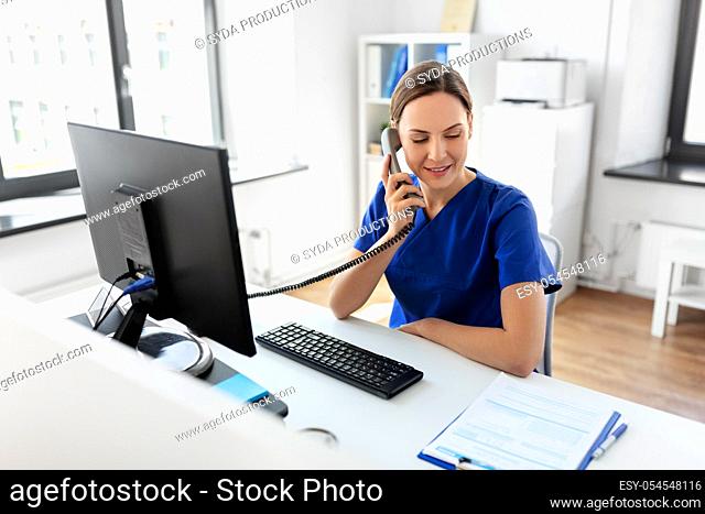 doctor with computer calling on phone at hospital