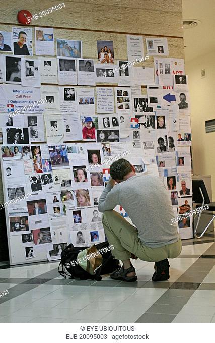Tsunami. A french tourist grieves while looking at pictures of french people missing along with hundereds of others posted up at the Bangkok Phuket hospital