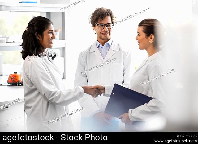 scientists shaking hands in laboratory