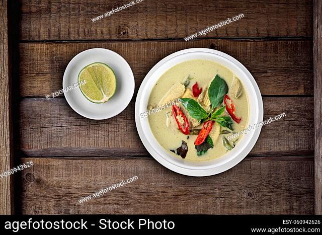 Top view Thai food chicken green curry isolated on rustic wooden table