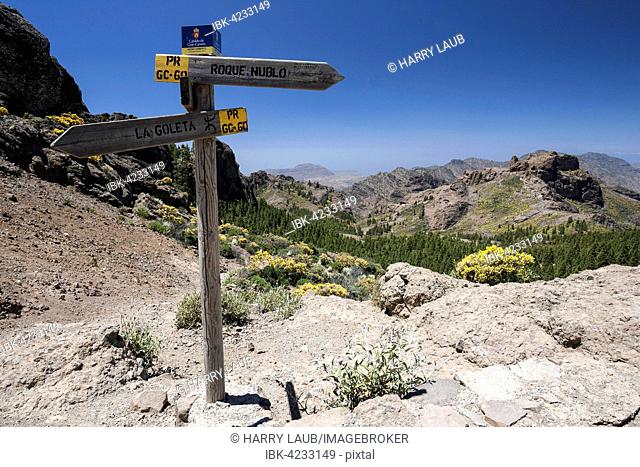 Hiking signpost on a hiking path to Roque Nublo, view of the mountains to the west of Gran Canaria, Canary Islands, Spain