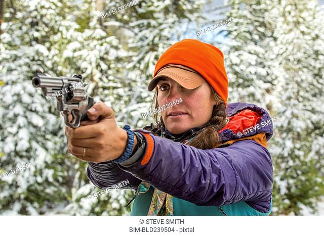 Caucasian woman aiming handgun in winter