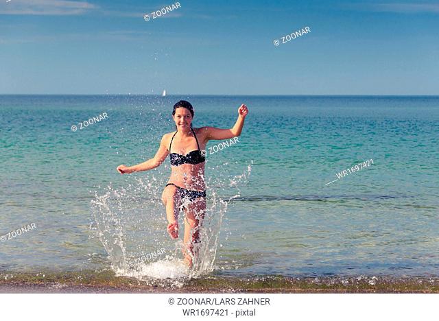 Happy woman frolicking on a tropical beach