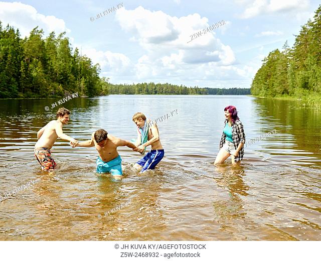 The group of the friends chilling out on the beach, summer day. Shot in southern Finland