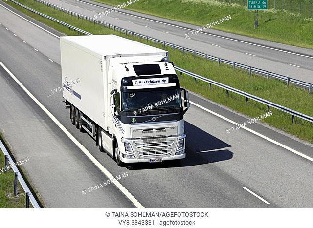 Salo, Finland. June 15, 2019. White Volvo FH semi trailer delivers goods on motorway E18 in South of Finland on a day of summer, above view.