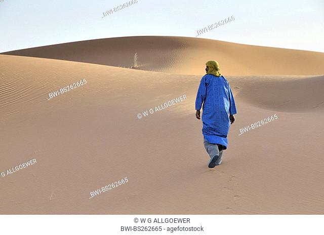 berber in traditional clothing walking in the desert, Morocco, Erg Chebbi