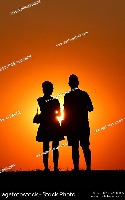 SYMBOL - 09 July 2023, Serbia, Belgrad: A woman and a man are standing at Kalemegdan Park at sunset. Thereby they can be seen as a silhouette