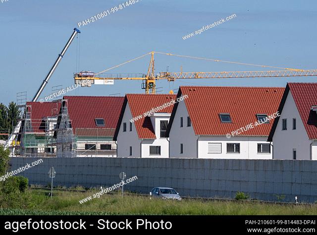 31 May 2021, Hessen, Nieder-Erlenbach: Scaffolding stands on the houses of a new housing estate in Frankfurt's Nieder-Erlenbach district