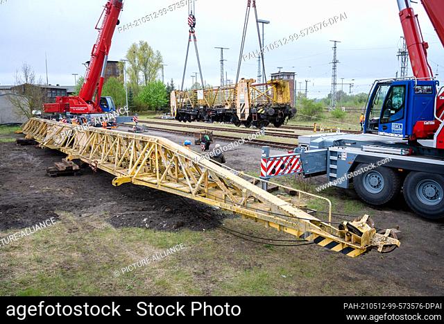 13 May 2021, Mecklenburg-Western Pomerania, Pasewalk: A track-laying crane is lifted by heavy-duty cranes to its final position in the Lokschuppen experience...