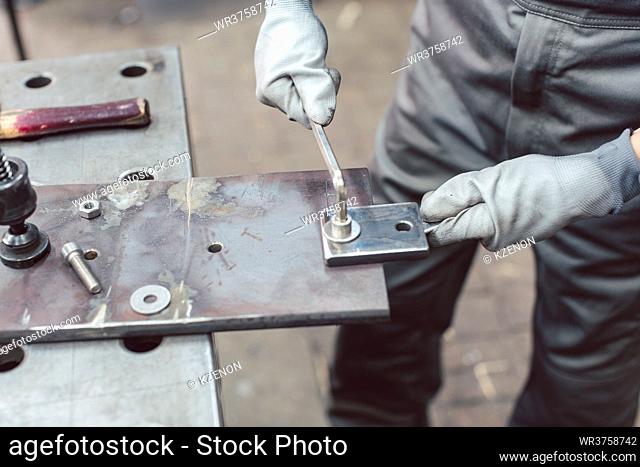 Close-up of woman metalworker in her workshop, focus on hands