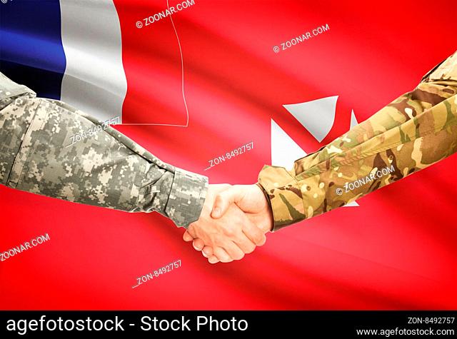 Soldiers shaking hands with flag on background - Wallis and Futuna