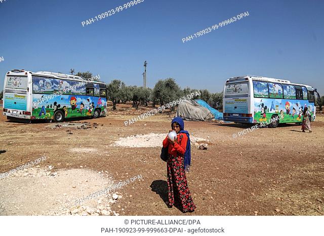 22 September 2019, Syria, Hazano: A Syrian child blows up a balloon outside buses which are converted into a classroom. Local teachers have invented the mobile...