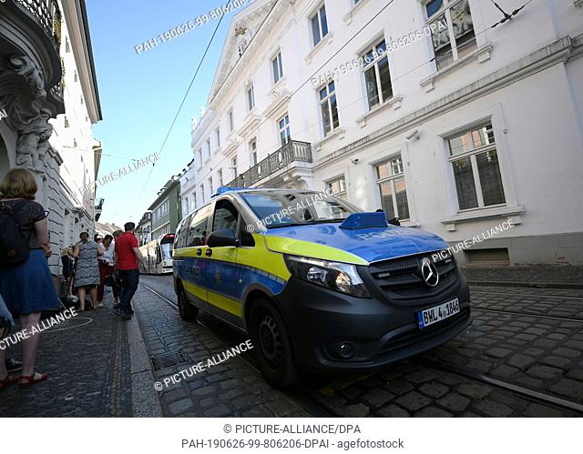 26 June 2019, Baden-Wuerttemberg, Freiburg: A police car drives on the street in front of the district court before the trial begins. Today (26.06