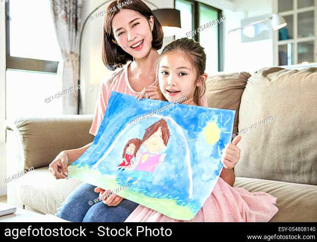 little girl showing Color pencil drawing family picture to her mother and celebrating mothers day