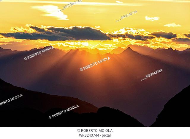 Sun rays at sunset on Pizzo Berro and Gerola Valley seen from San Marco Pass, Orobie Alps, Bergamo province, Lombardy, Italy, Europe