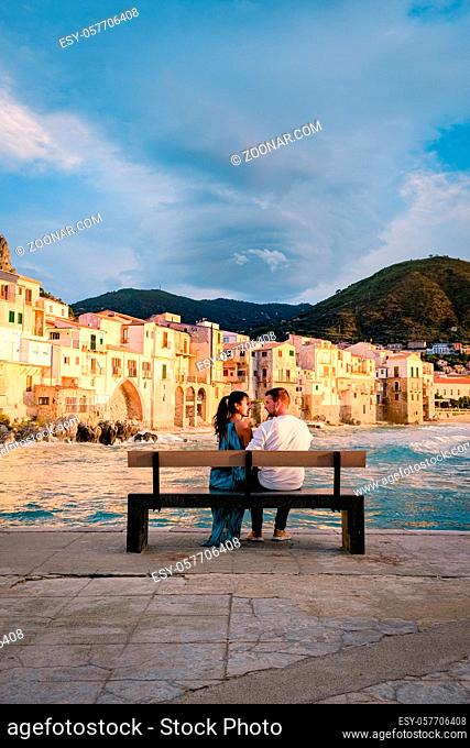 couple on vacation Sicily visiting the old town of Cefalu, sunset at the beach of Cefalu Sicily, old town of Cefalu Sicilia panoramic view at the colorful...