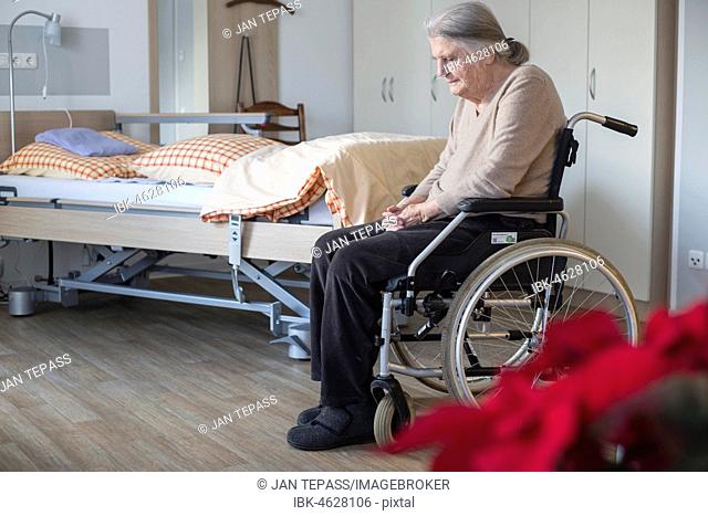 Demented Senior in a wheelchair alone in her room in a nursing home, Cologne, North Rhine-Westphalia, Germany