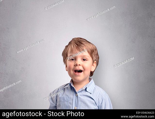 Adorable little boy portrait with empty grey wall background