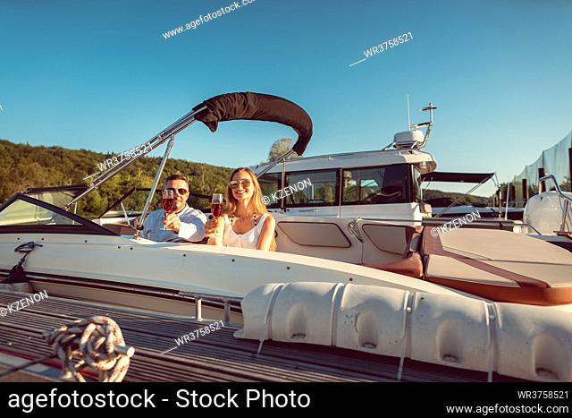 Couple getting ready to drive their motorboat on the river for some relaxation in spare time