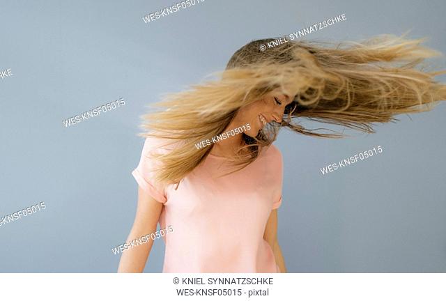 Laughing young woman tossing her hair