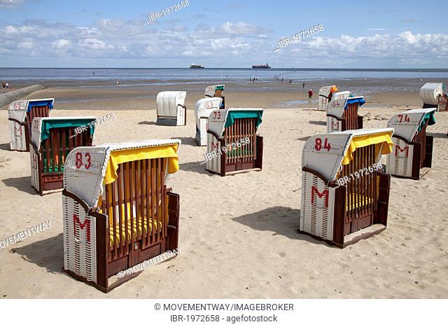 Roofed wicker beach chairs on a sandy beach, behind the Wadden sea and ships, Cuxhaven, Lower Saxony, North Sea, Germany, Europe, OeffentlicherGrund