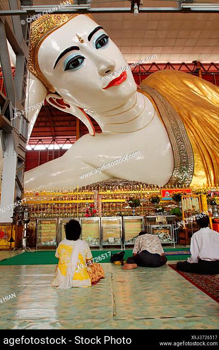 the reclining Buddha of Chaukhtatgyi pagoda with prayers, yangon, Myanmar (Burma)