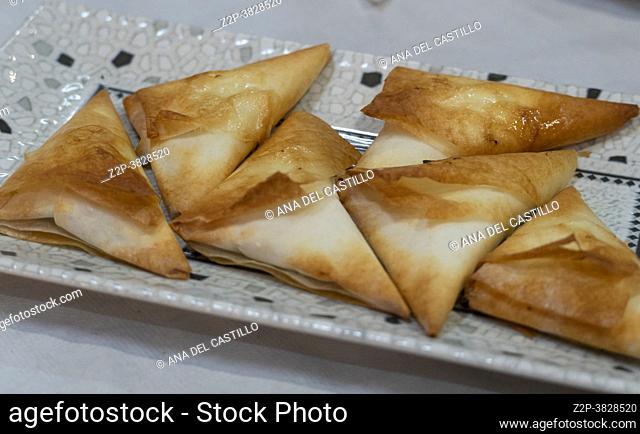 Spanish Tapas plate with golden fried filled pastry triangles and sauce