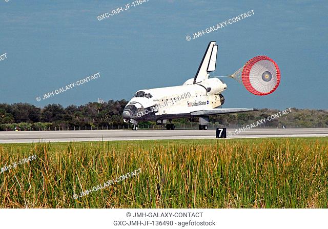 Space Shuttle Atlantis' drag chute is deployed as the spacecraft rolls toward wheels stop on runway 15 of the Shuttle Landing Facility at NASA's Kennedy Space...