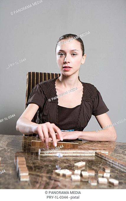 Portrait of a young woman playing mahjong game