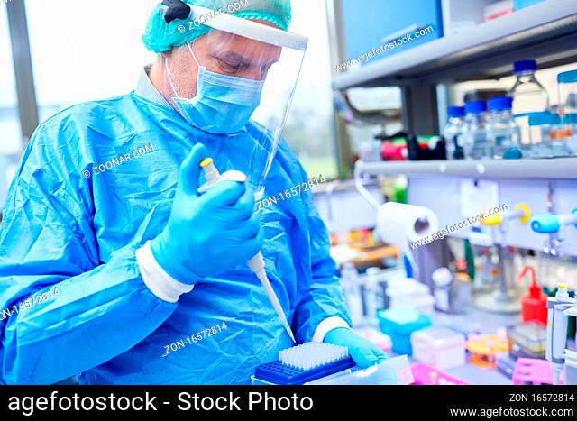 Mediziner mit Pipette im Labor analysiert Covid-19 Schnelltests bei Coronavirus Pandemie