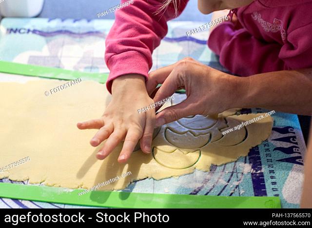 Bamberg, Germany November 22, 2020: Symbolbilder - 2020 - From the homemade dough, which is rolled out on a mat, a child cuts out cookies in different shapes