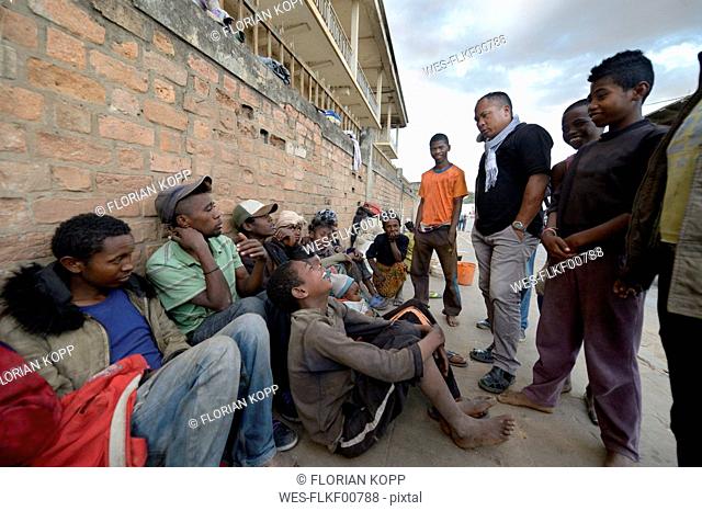 Madagascar, Fianarantsoa, Social worker talking to a group of homeless people
