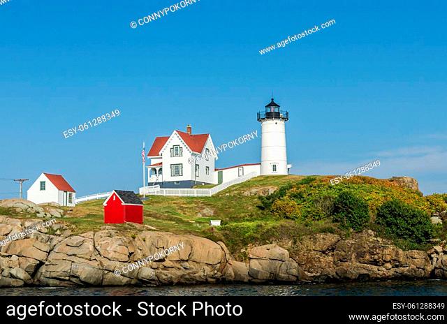 Close up of the Cape Neddick Lighthouse against blue sky. The Lighthouse, also known as Nubble Light, is located on a small rock island on the Atlantic Ocean in...