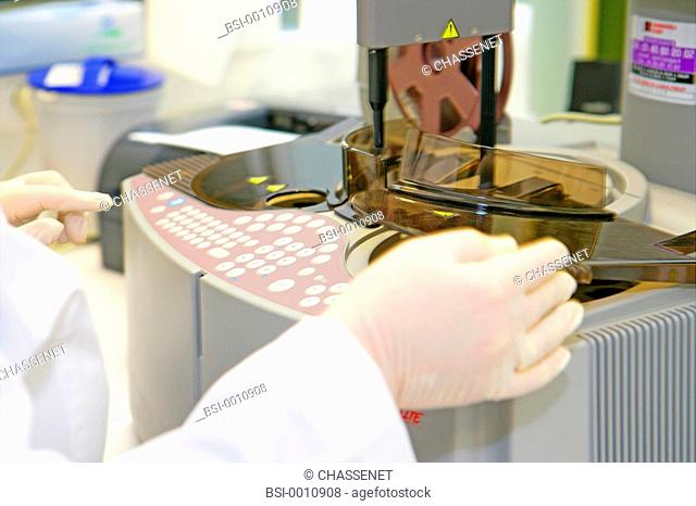 Photo essay from laboratory. Automaton of hemostasis Diagnostica Stago. Analysis of blood coagulation. The technician is programming the automaton