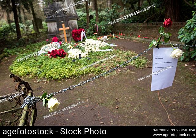 23 January 2020, Hamburg: Flowers lie on the grave of the actor Jan Fedder in the Ohlsdorf cemetery. In front of it hangs a chain with a sign saying ""I sleep
